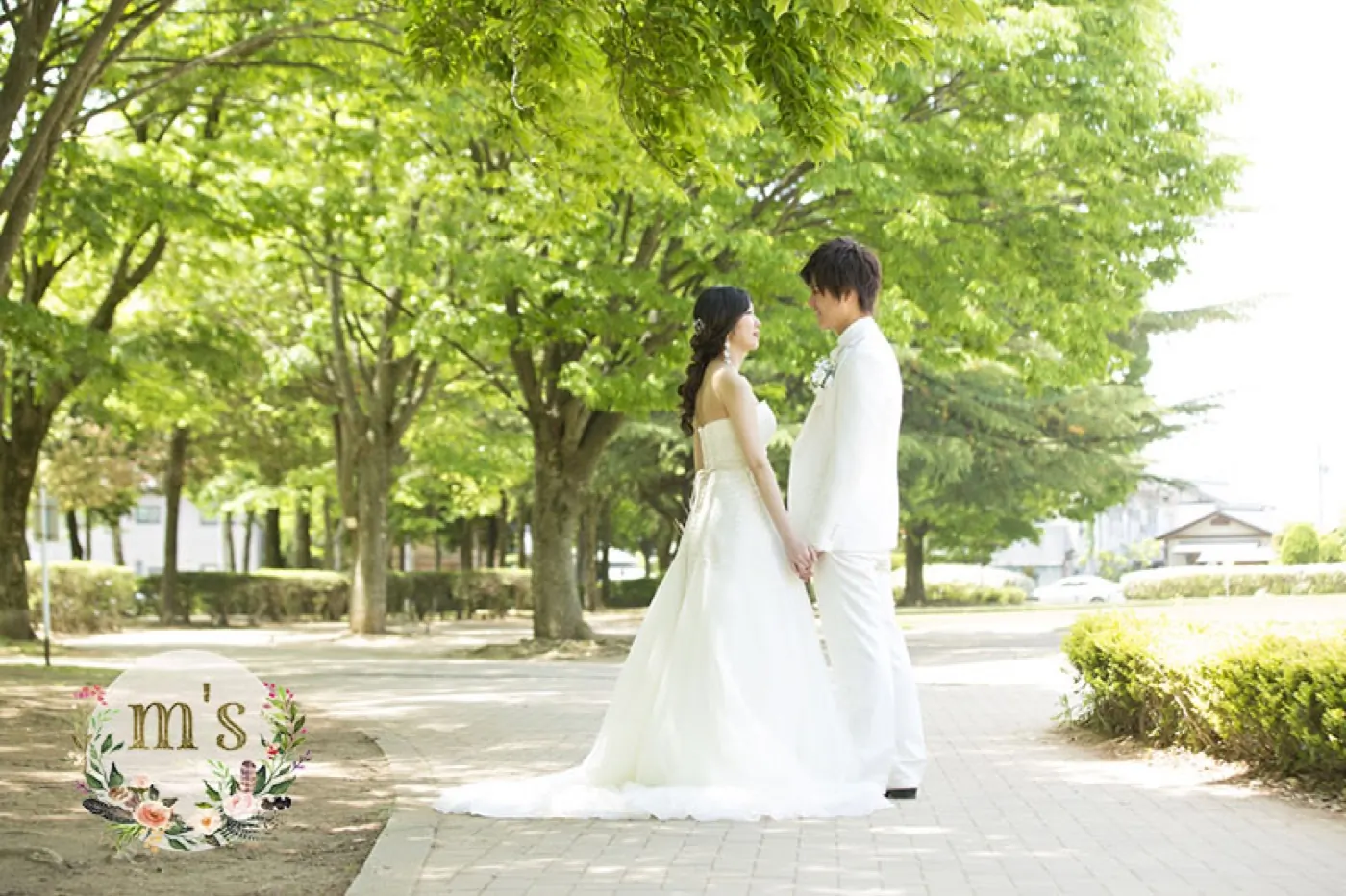 新緑の並木道でウェディングドレスの裾を広げる花嫁