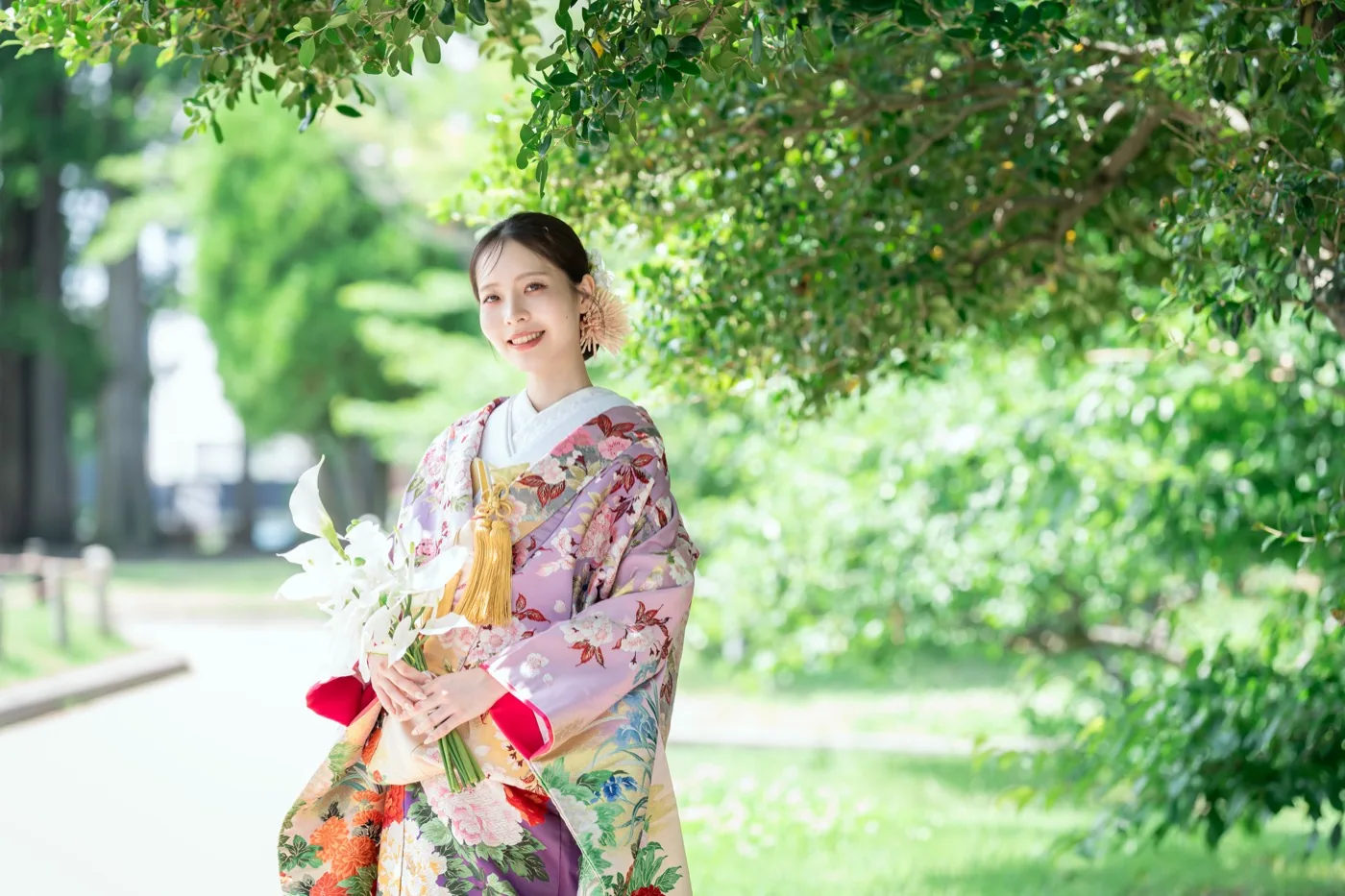 松本城公園の木漏れ日の下で、白い花を持つ色打掛の花嫁