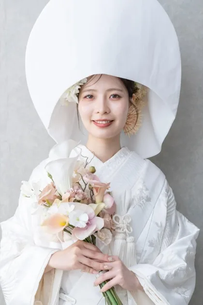 白無垢に綿帽子を合わせ、ブーケを持って微笑む花嫁。松本のスタジオ撮影