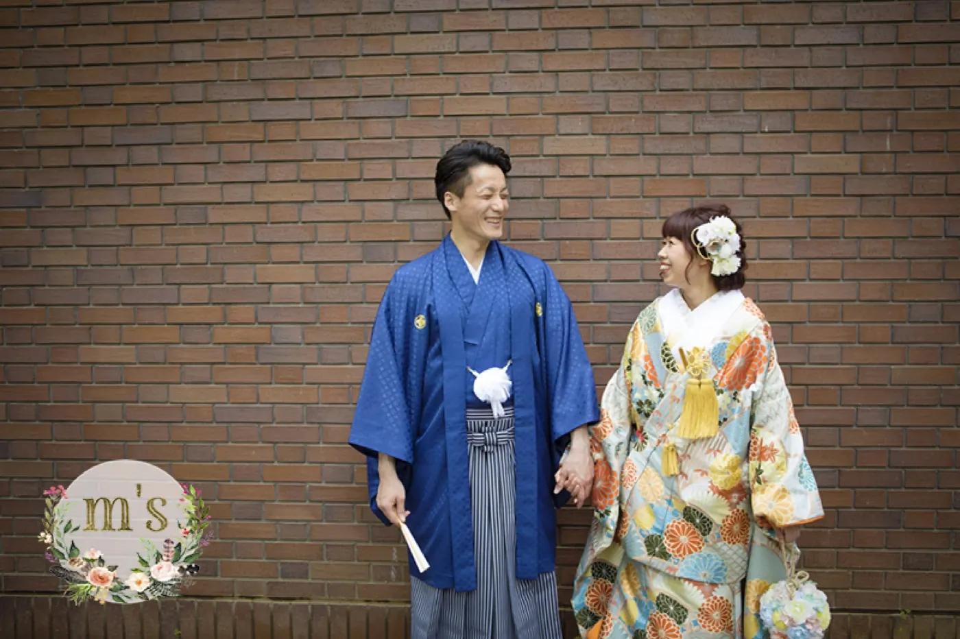 青の紋付を着た花婿と、色打掛の花嫁の立ち姿