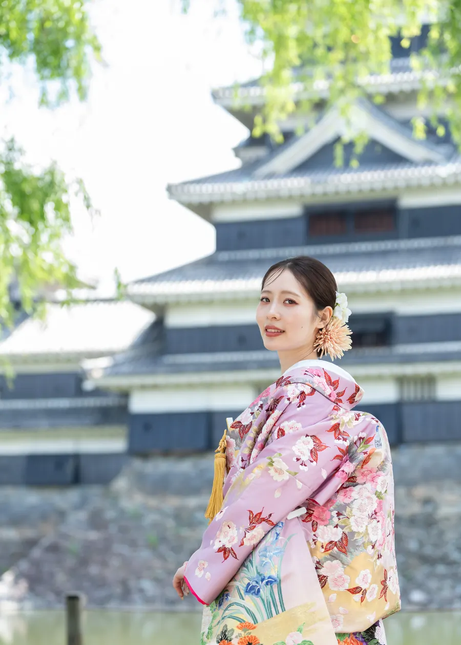 松本城を背に振り返る、淡い色打掛の花嫁